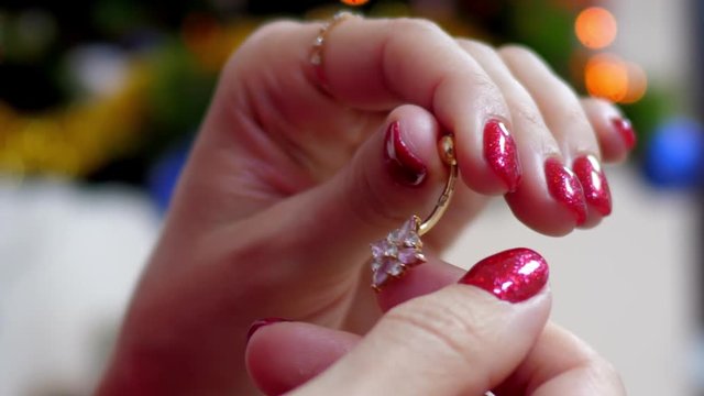 slow motion close view girl with shining red manicure shows gold navel piercing banana with turning ball