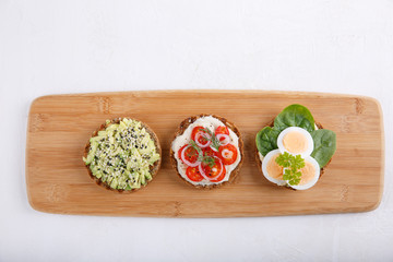 Different kinds of whole grain bread sandwiches on white background.