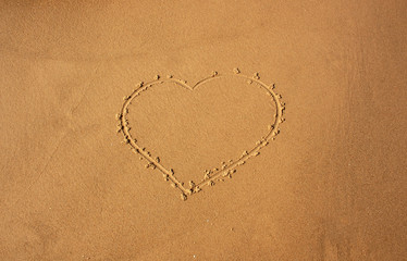 Fototapeta na wymiar heart depicted on sea sand for background