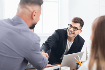 Boss congratulating on promotion male subordinate at meeting
