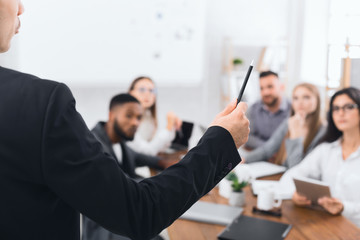 Boss explaining financial plan to colleagues at meeting