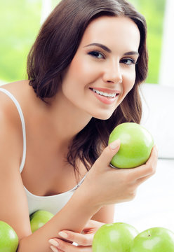 happy smiling woman with green apples, indoors