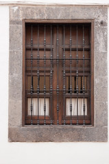 old window with shutters and iron bars