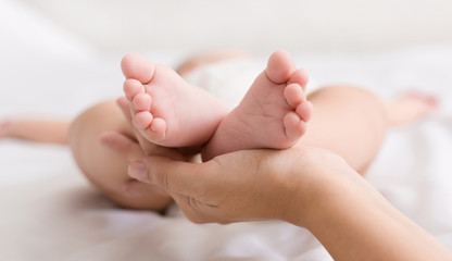 Obraz na płótnie Canvas Little baby feet in mother hands closeup