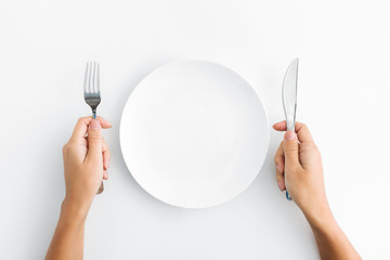 Whte plate with silver fork and knife on white background - obrazy, fototapety, plakaty