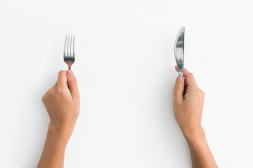 Woman hands holding fork and knife on white background