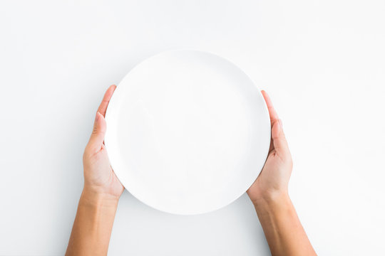 Female Hands Holding Empty Plate On White Background