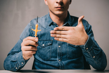 cropped view of man showing yellow syringe for microchipping