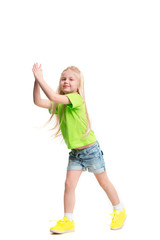 Full length portrait of cute little kid girl in stylish jeans clothes looking at camera and smiling, standing against white studio wall. Kids fashion concept