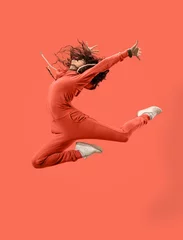 Poster Freedom in moving. Mid-air shot of pretty happy young woman jumping and gesturing against coral studio background. Runnin girl in motion or movement. Human emotions and facial expressions concept © master1305