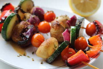 Grilled colorful vegetables skewers on white background.
