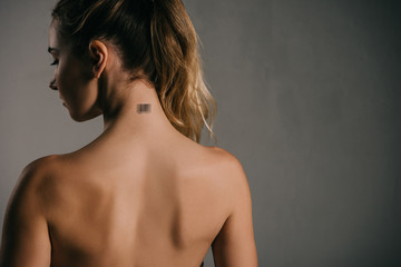 back view of woman with coded neck on grey background