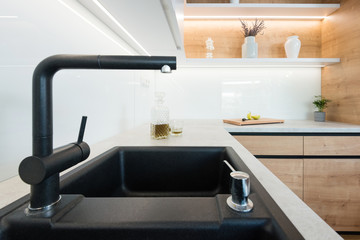 Detail of black wash basin with faucet in modern kitchen