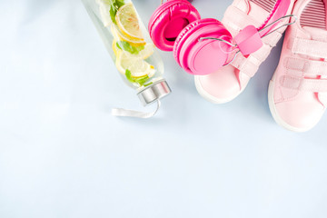 Sport and fitness creative layout, dumbbells, women's sneakers, jump rope, notebook, bottle with detox water with lemon and mint, bright trendy background, top view,  creative layout copy space