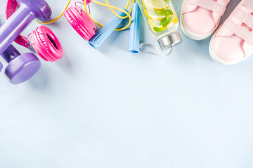 Sport and fitness creative layout, dumbbells, women's sneakers, jump rope, notebook, bottle with detox water with lemon and mint, bright trendy background, top view,  creative layout copy space