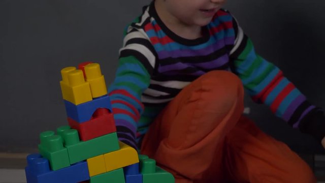 Cute children preschoolers play in color cubes, blocks. Boys are actively building new forms and expressing their emotions. Brothers study and get ready for school. Kids are happy to play together