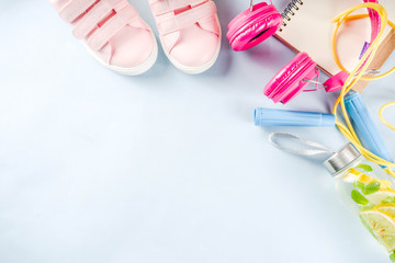 Sport and fitness creative layout, dumbbells, women's sneakers, jump rope, notebook, bottle with detox water with lemon and mint, bright trendy background, top view,  creative layout copy space