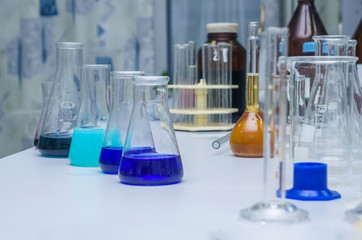 Laboratory glassware with multi-colored liquid on table. Chemical analysis