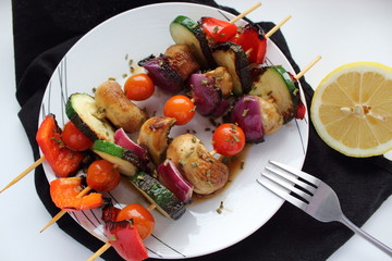 Top view of vegetable skewers on a black napkin and white background. 