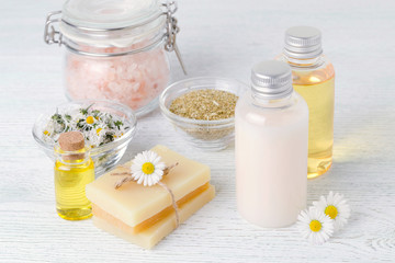 Obraz na płótnie Canvas natural cosmetic products with fresh and dried chamomile flowers, soap, salt and oil