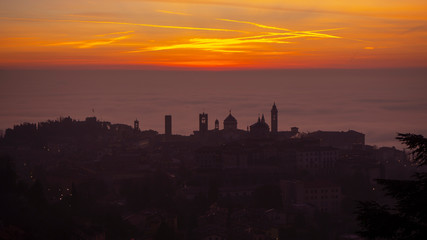 Fototapeta premium Bergamo, one of the most beautiful city in Italy. Amazing landscape of the old town and the fog covers the plain at sunrise