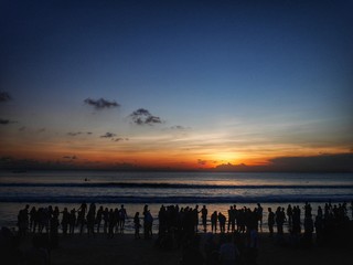南国の夏の夕焼け、ビーチに集まる人々