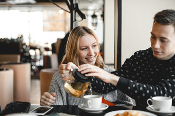 The guy pours tea to his girlfriend