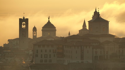 Fototapeta na wymiar Bergamo, one of the most beautiful city in Italy. Amazing landscape of the old town and the fog covers the plain at sunrise