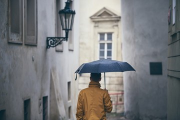 Lonely man with umbrella in rain