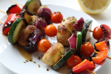 Vegetable skewers on white plate.