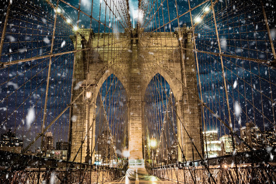 Brooklyn Bridge New York City with snowflakes falling during winter snow storm © littleny