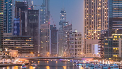 Fototapeta na wymiar Evening Dubai marina city centre with floating vessels day to night timelapse