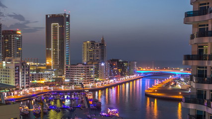Fototapeta premium An Aerial view of Dubai Marina Towers in Dubai day to night timelapse