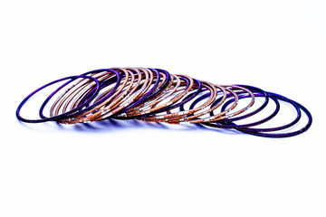 Close up of purple and orange colored metal bangles isolated on white.