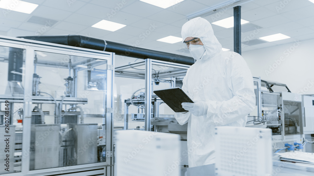 Poster quality control check: scientist using digital tablet computer and wearing protective suit walks thr