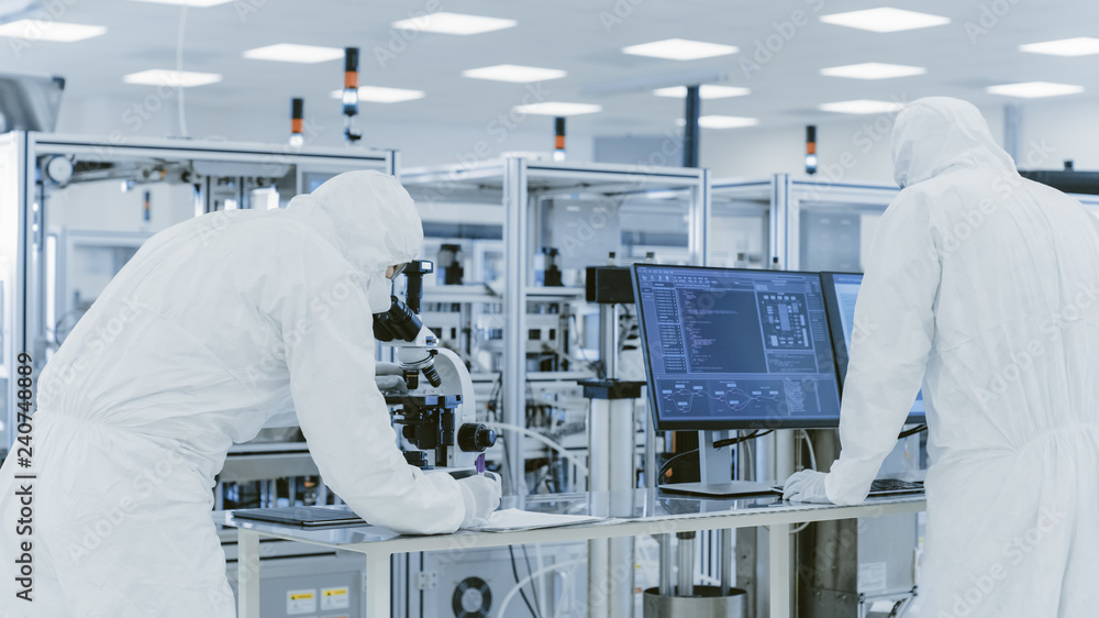 Poster in laboratory scientists in protective clothes doing research, using microscope and entering data in