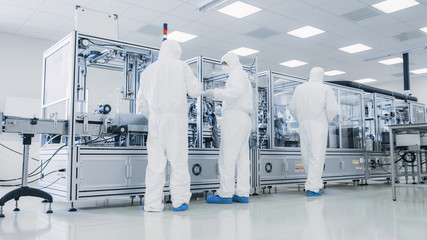 In the Manufacturing Facility Team of Scientist Wearing Sterile Protective Coverall Set's up /...