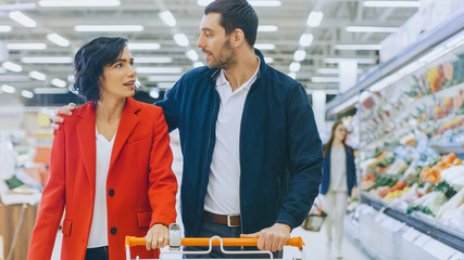 At the Supermarket: Happy Young Couple Walks Through Fresh Produce Section of the Store, They Talk,...