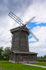 Ancient wooden windmill on green grass