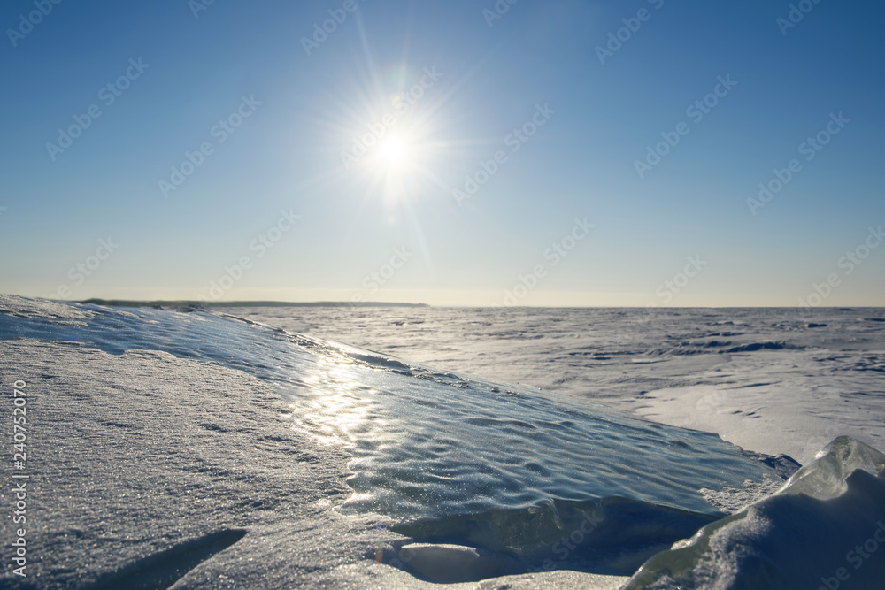 Wall mural transparent fragments of ice and snow forms against the backdrop of the endless snowy landscape