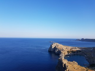 Magnificent drone view of tranquil blue sea and wonderful rocky cliff on beautiful sunny day.