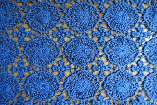 Thin blue lacy fabric on wood from above