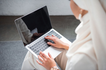 cropped shot of young muslim woman using laptop with blank screen