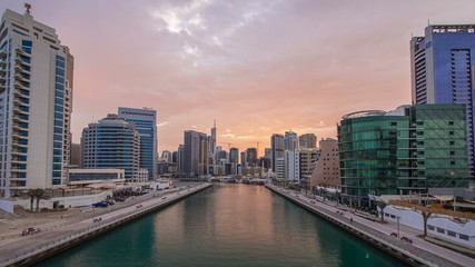 View of Dubai Marina Towers and canal in Dubai night to day timelapse