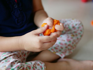 Close up of little baby's hands squeezing playdough - playing dough promotes baby's creativity,...