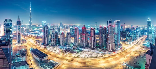 Foto auf Leinwand Spektakuläre urbane Skyline mit farbenfroher Stadtbeleuchtung. Luftbild auf Autobahnen und Wolkenkratzern von Dubai, Vereinigte Arabische Emirate. © Funny Studio