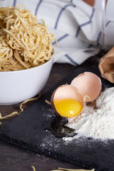 close up of broken egg, flour and noodles egg red wine.