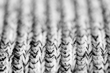 White and black knitted woolen texture background close up