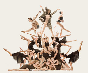 The group of modern ballet dancers dancing on gray studio background. Collage
