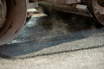 Closeup of steam roller machine finishing up roadwork